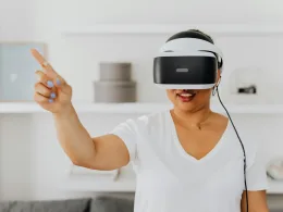 Woman using a VR headset for augmented reality interaction, gesturing while immersed in virtual environment.
