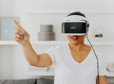 Woman using a VR headset for augmented reality interaction, gesturing while immersed in virtual environment.