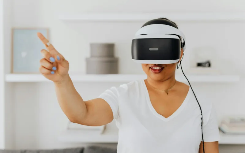 Woman using a VR headset for augmented reality interaction, gesturing while immersed in virtual environment.