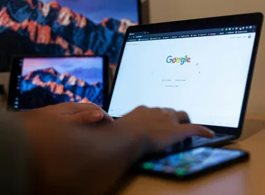 Hands typing on a laptop with Google on screen, in a remote work setup in Milan, Italy.