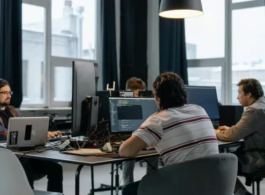 Team of developers working together on computers in a modern tech office.